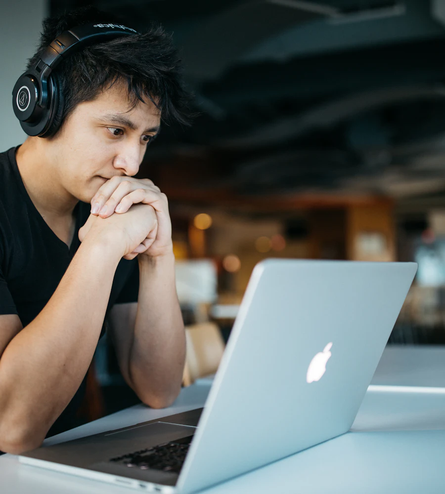 Estudante de fone de ouvido concentrado diante do notebook