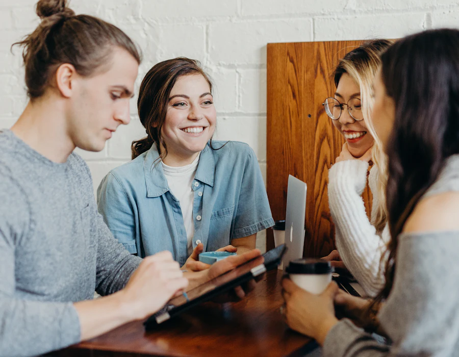 Jovens conversando e trabalhando juntos em volta de uma mesa